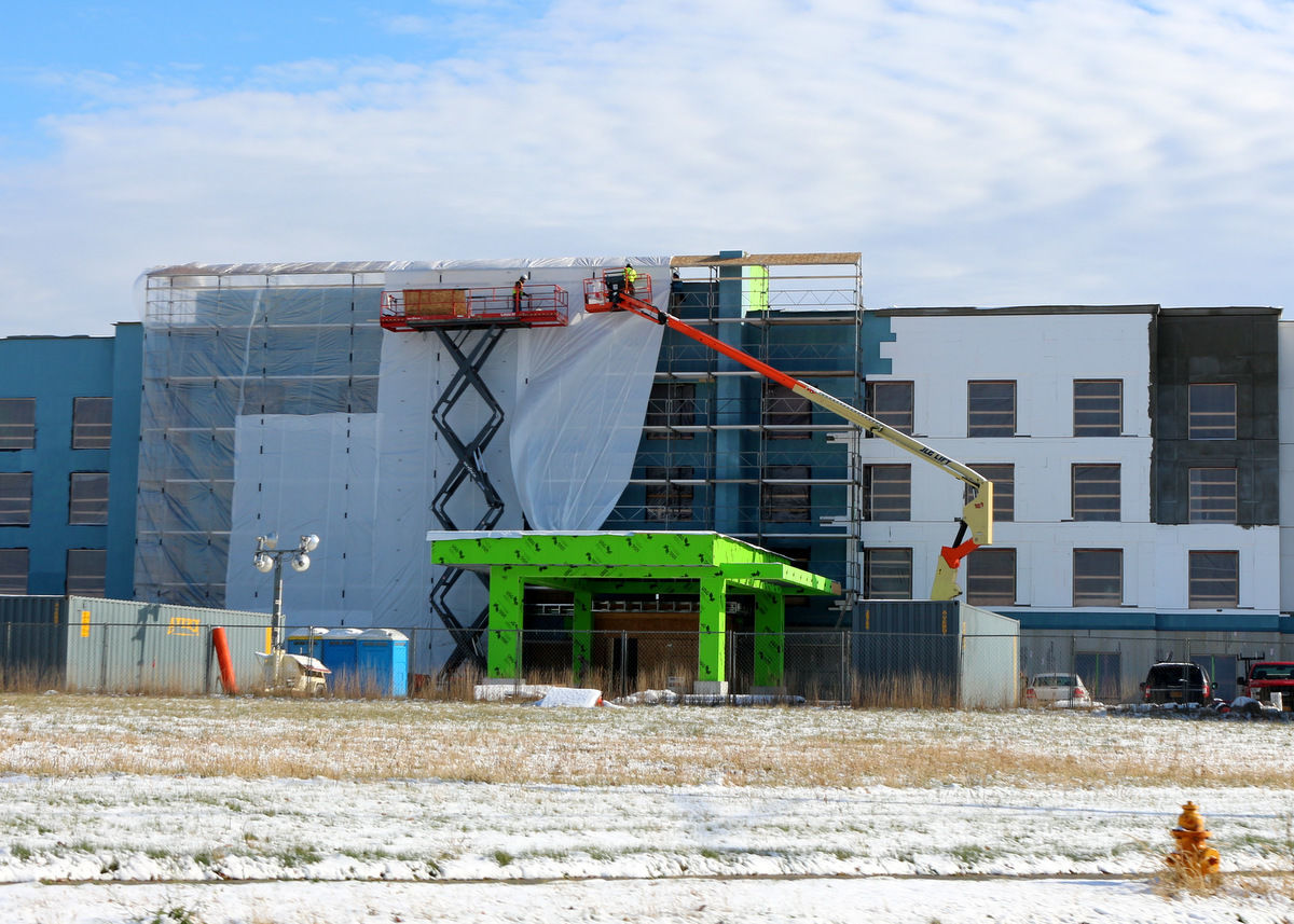 Workmen install plastic barrier at Olean Gateway hotel